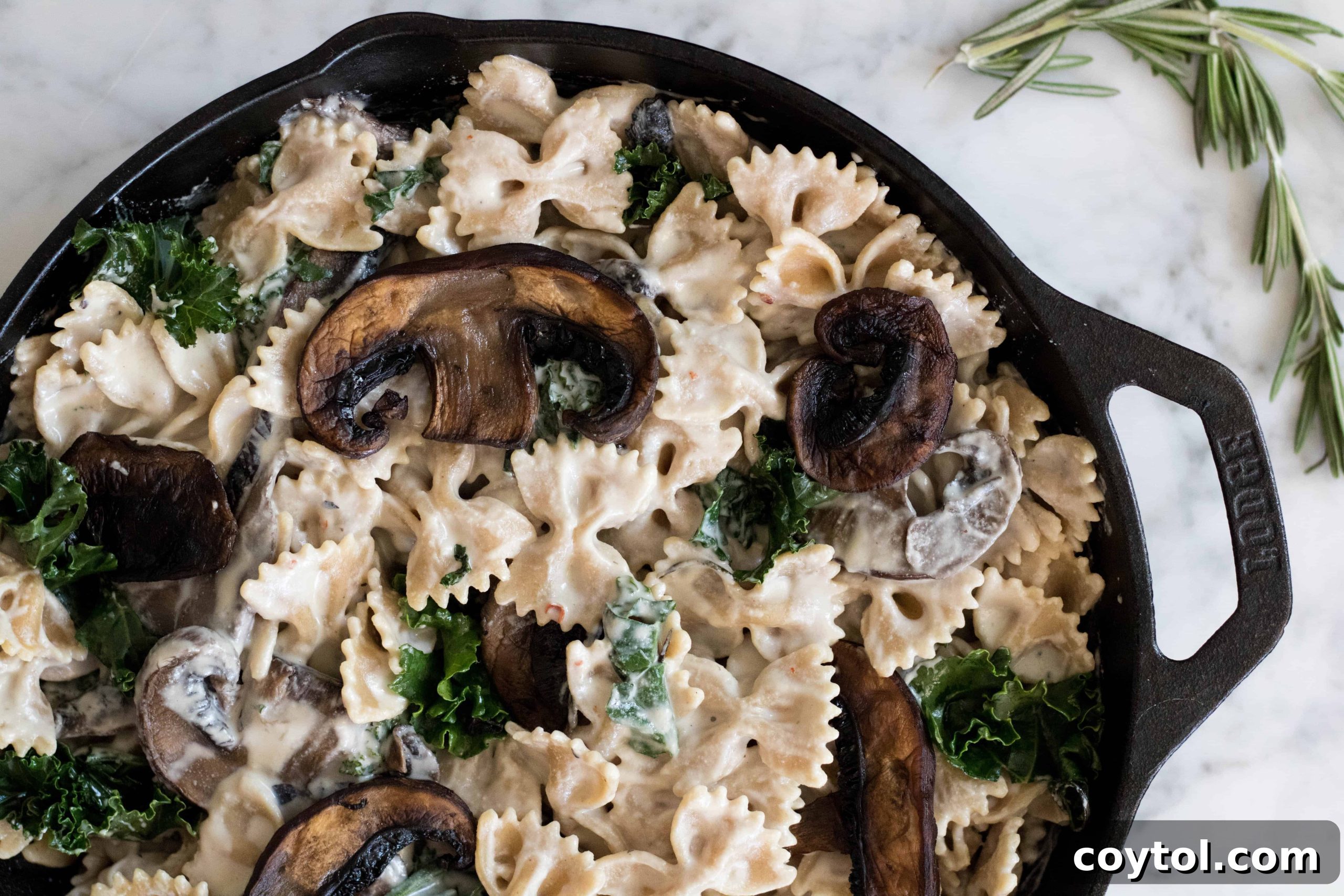 Vegan creamy Kale & mushroom pasta, showing a close-up of the finished dish with rich cashew cream sauce, mushrooms, and kale intertwined with pasta.