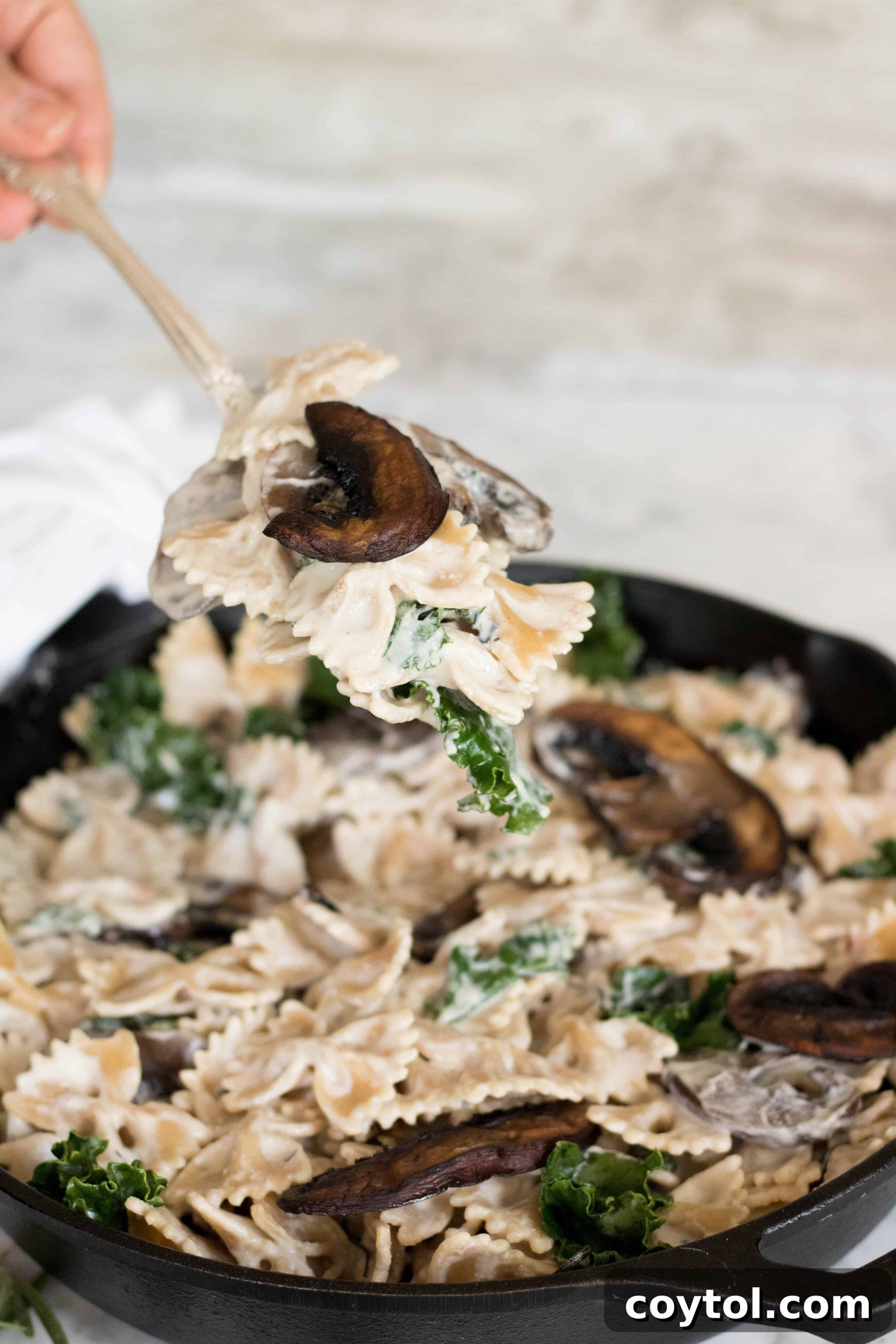 A bowl of creamy vegan mushroom pasta, garnished with fresh herbs and a sprinkle of red pepper flakes.