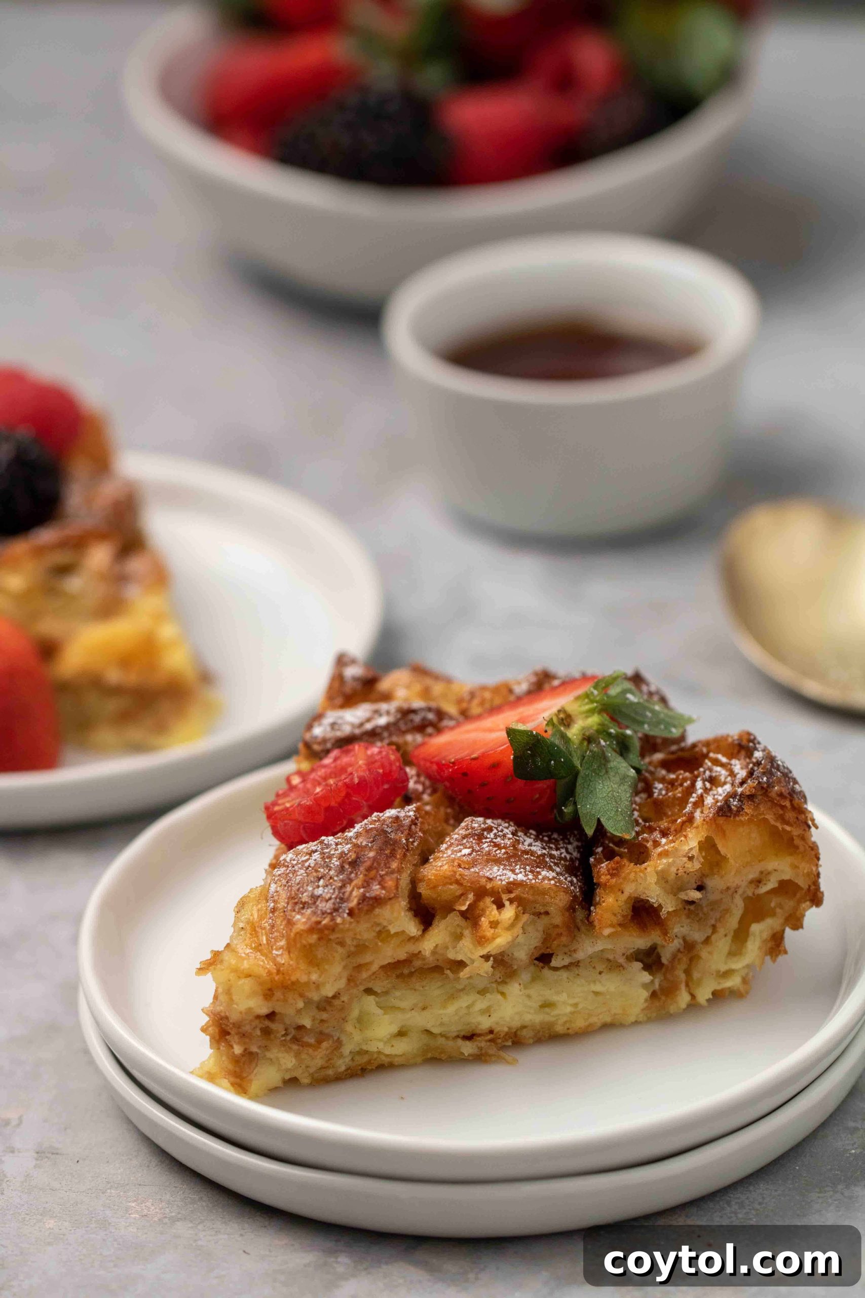 Two slices of golden Croissant French Toast Bake on a white plate