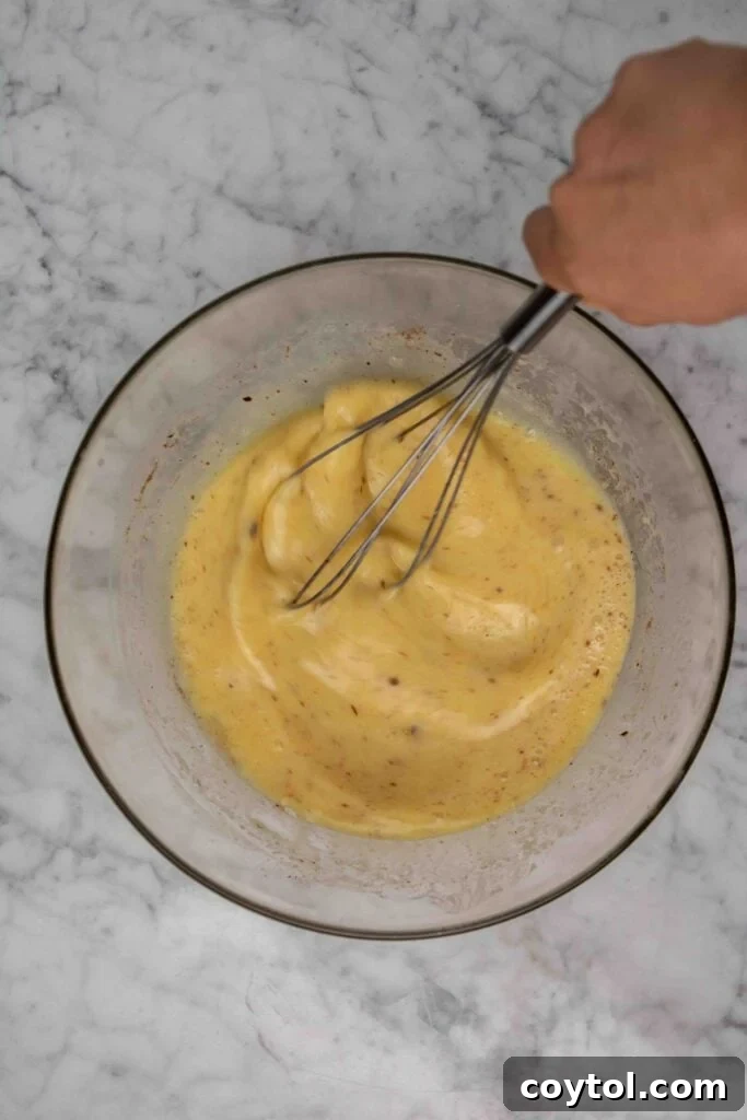 Adding milk and cream to the egg mixture for French toast custard