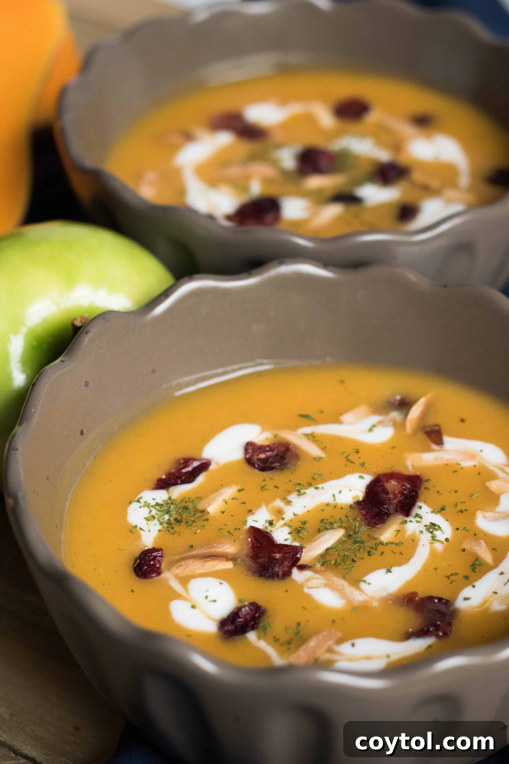 Close-up of a bowl of creamy butternut squash soup garnished with fresh herbs