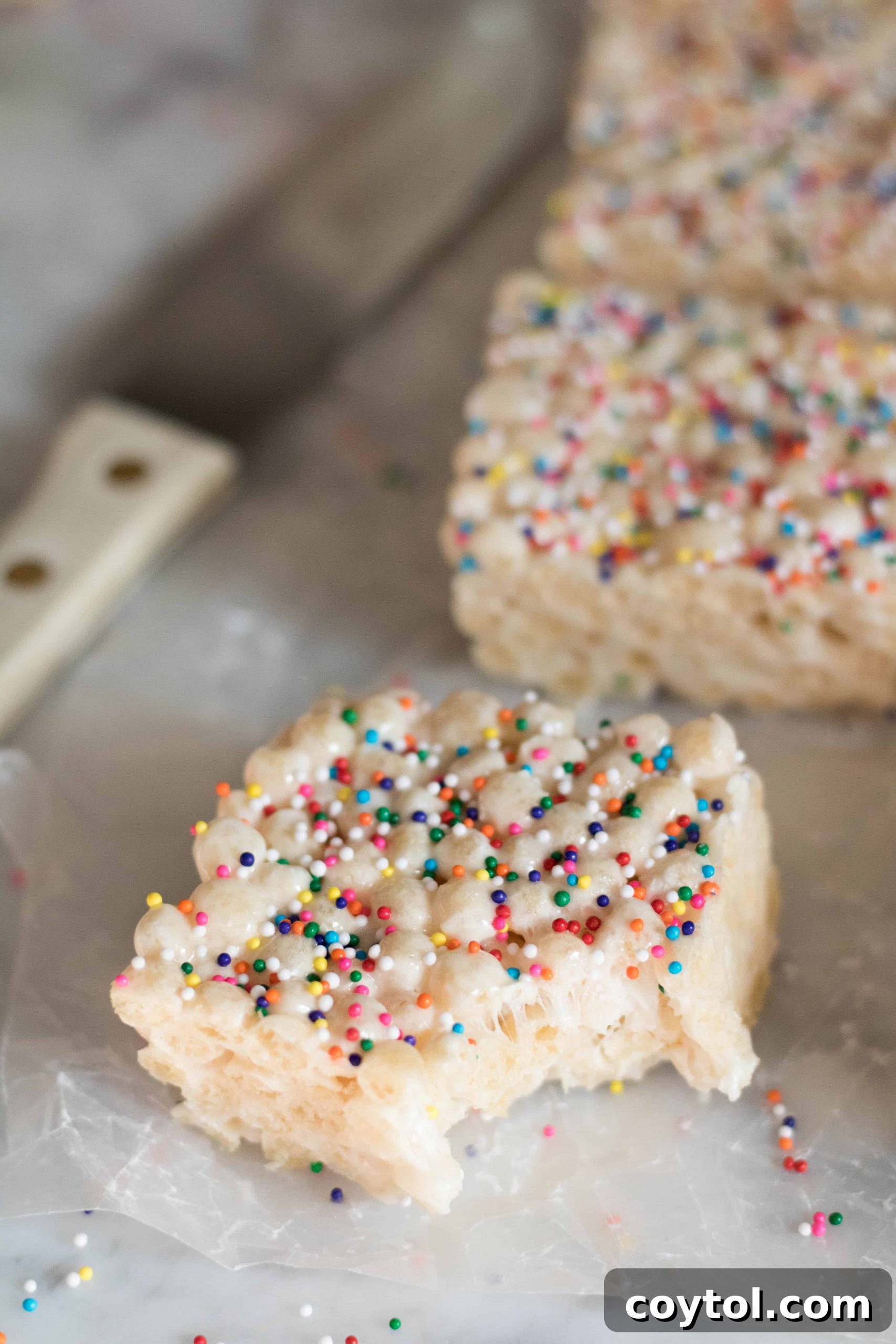 A beautifully composed shot of Quinoa Pop Krispie Treats, highlighting their texture and colorful sprinkles.