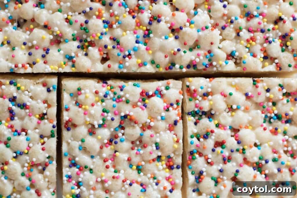 A stack of three Quinoa Pop Krispie Treats, perfectly cut and ready to eat, with sprinkles.
