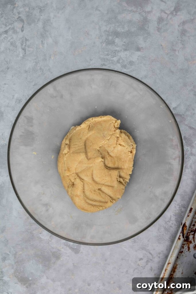 Pressing the almond flour dough into a baking pan.