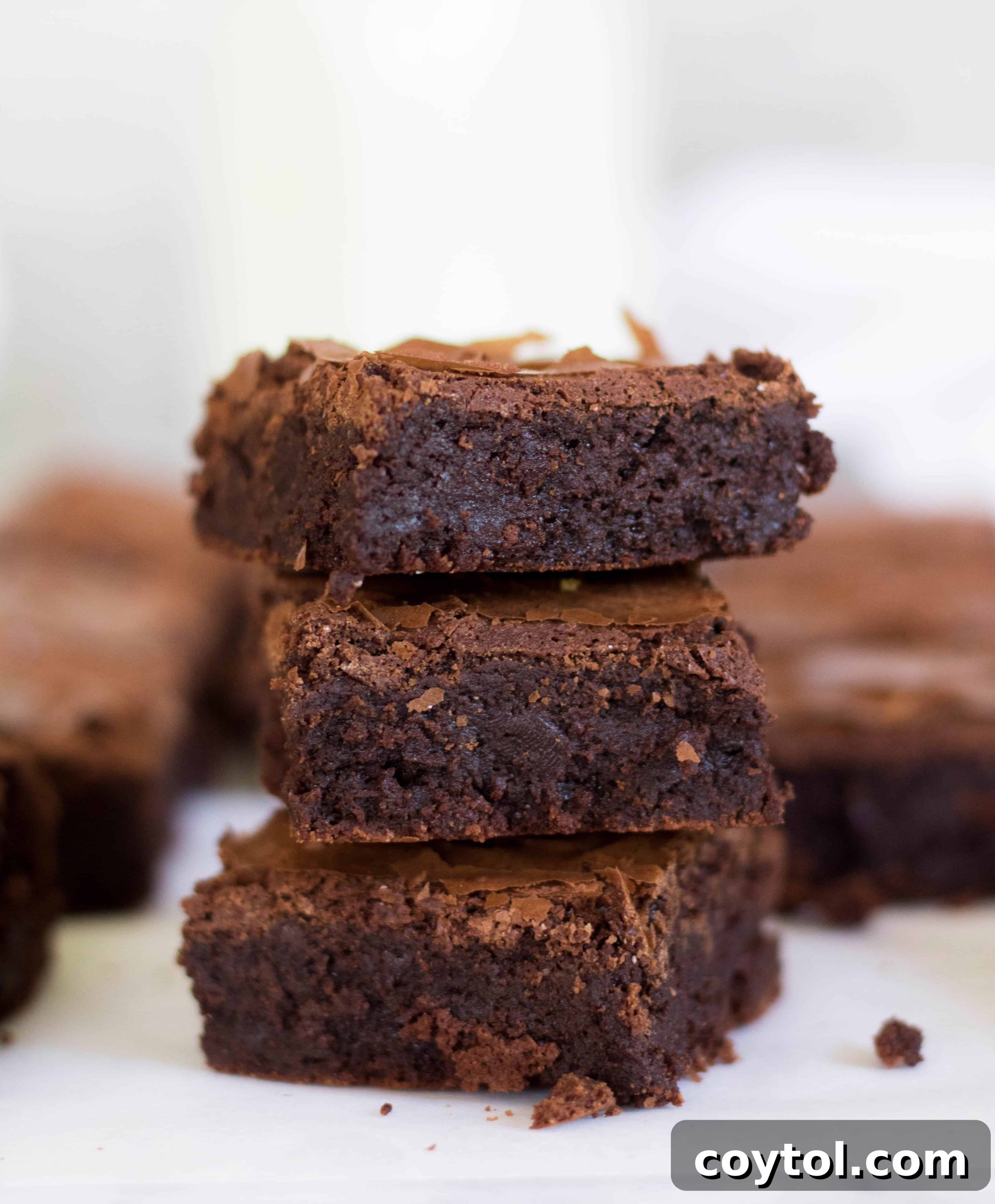 Bakery-style brownies with no cocoa powder, boasting a shiny crackled top and dense, gooey interior.