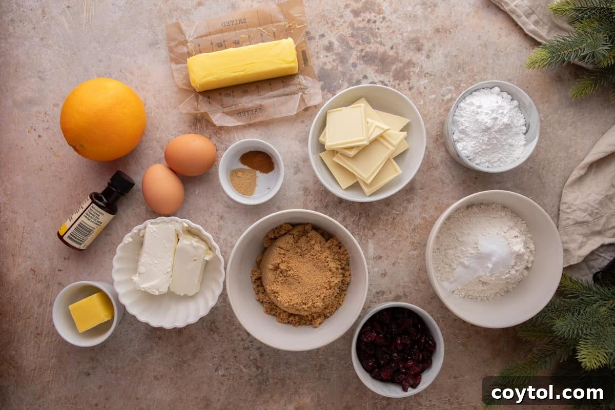Homemade Cranberry Bliss Bars Surpassing Starbucks 3 Overhead view of ingredients for cranberry bliss bars including butter, eggs, flour, brown sugar, dried cranberries, white chocolate, orange, spices, cream cheese, and powdered sugar arranged on a counter.