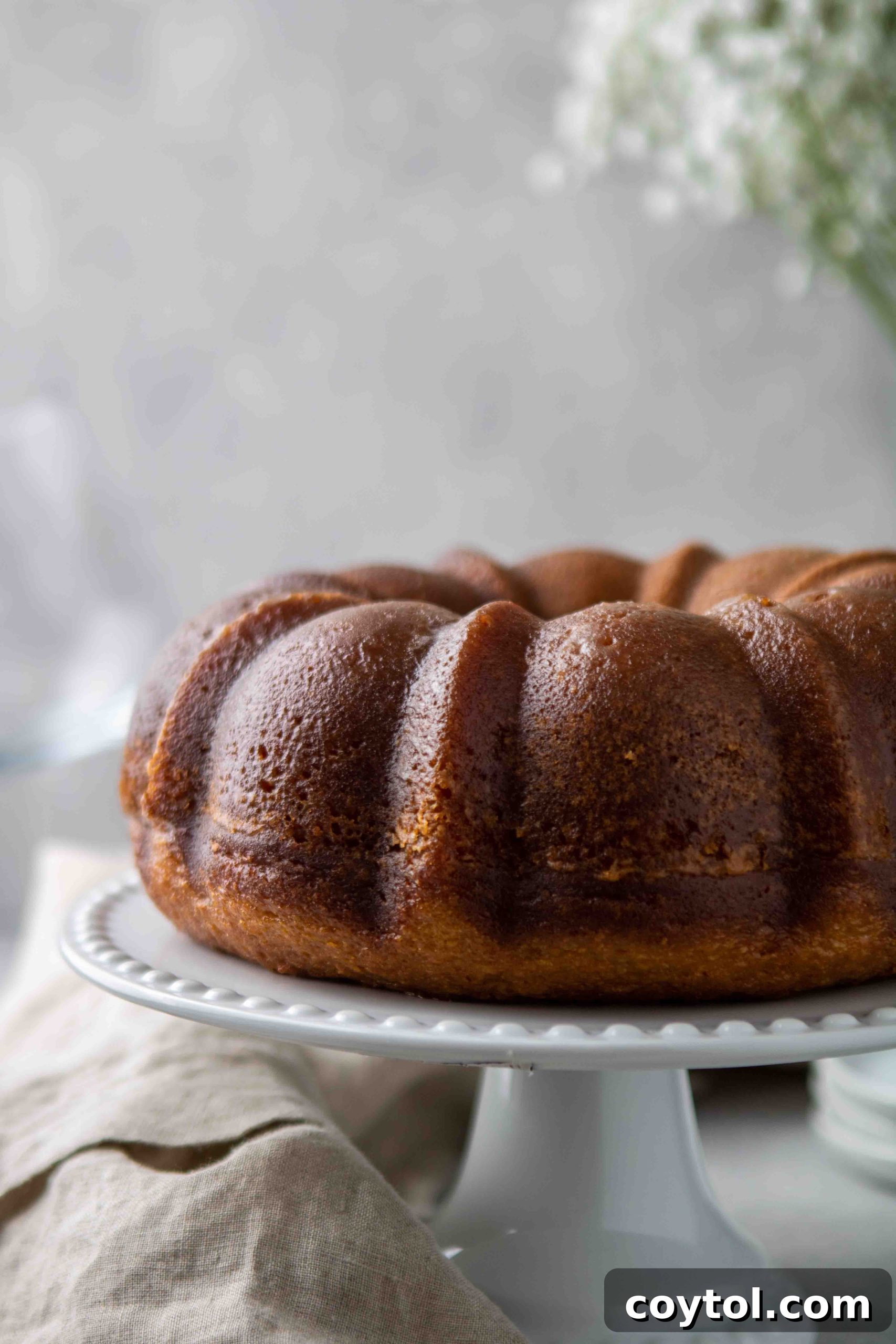 The Ultimate Not-Too-Sweet Bundt Cake 14 Full bundt cake with white wine glaze on a cake stand