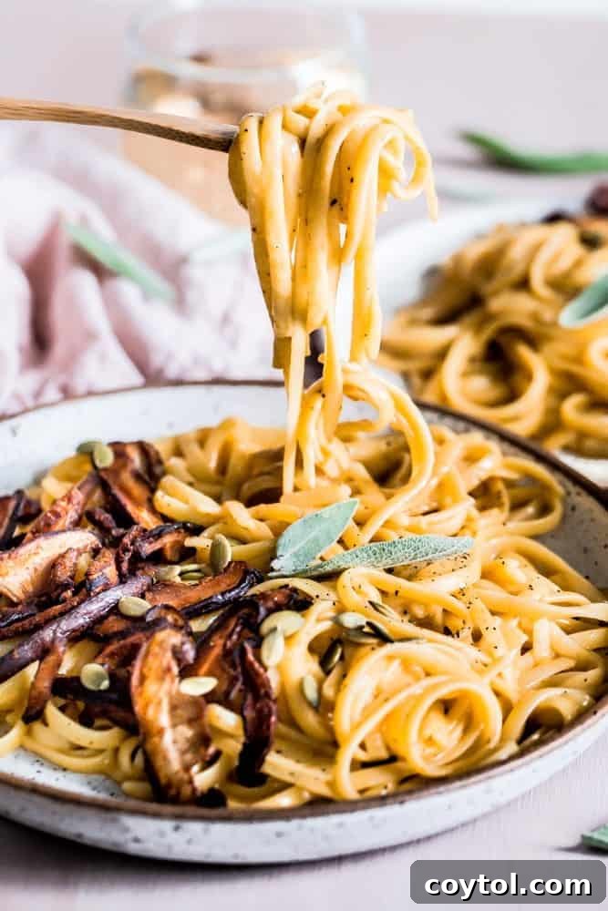 Delicious pumpkin vegan pasta generously topped with savory shiitake mushrooms, a perfect fall dinner.