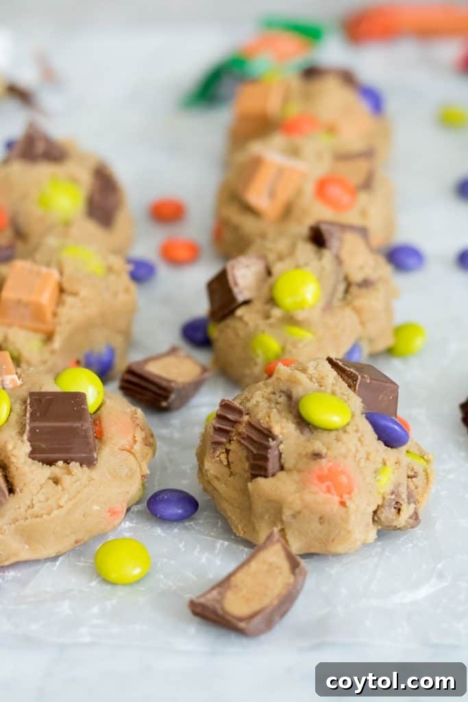 Bowl of cookie dough mixed with a generous amount of chopped colorful chocolate and various candies