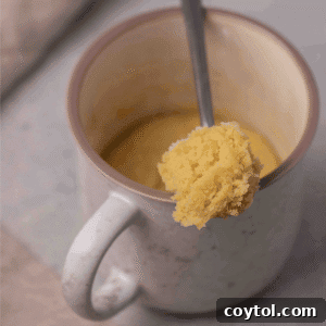 Mug sugar cookie in a spoon to see texture, showcasing its soft and chewy consistency.