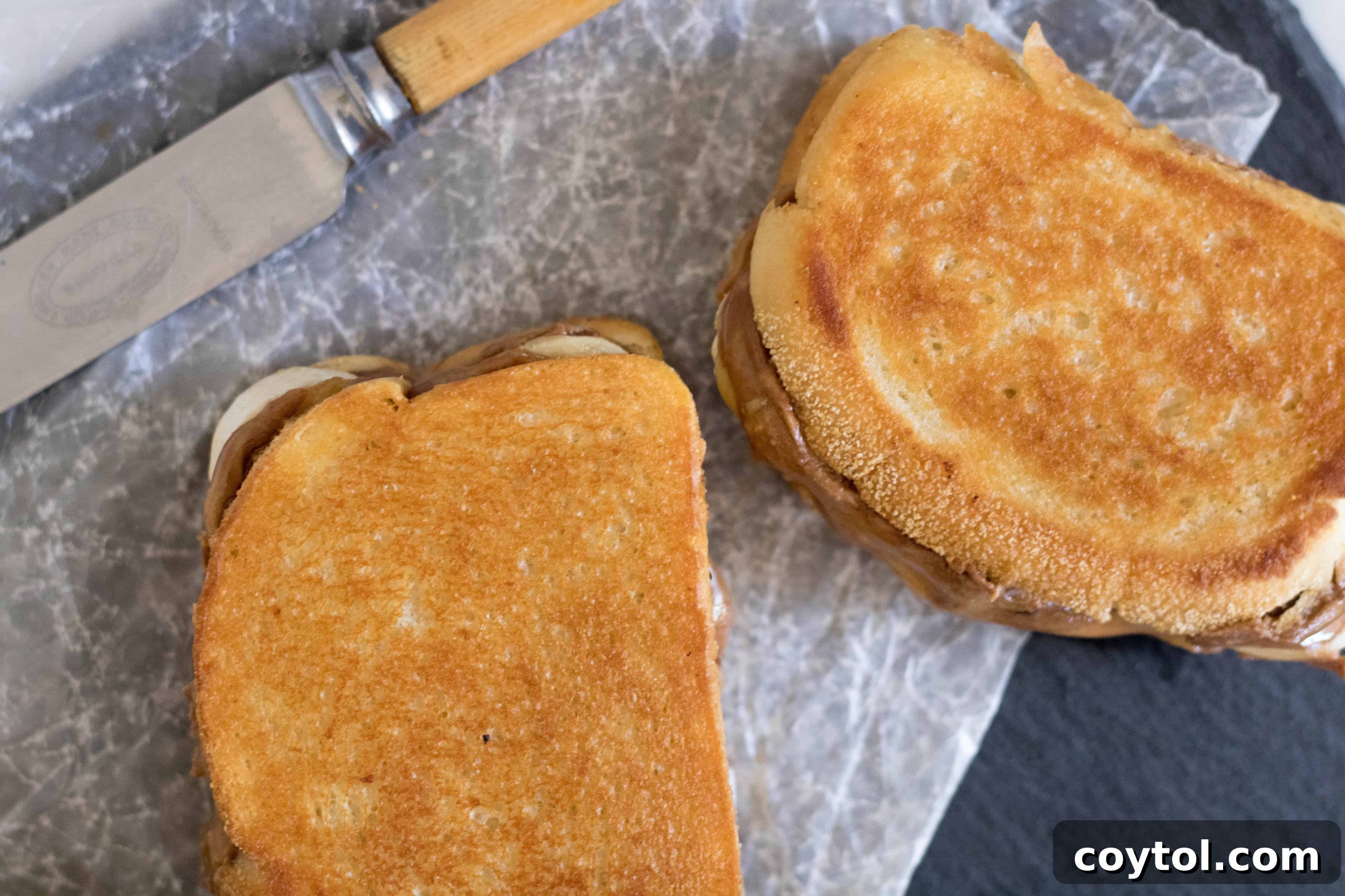 Two slices of English muffin bread, buttered and ready for grilling