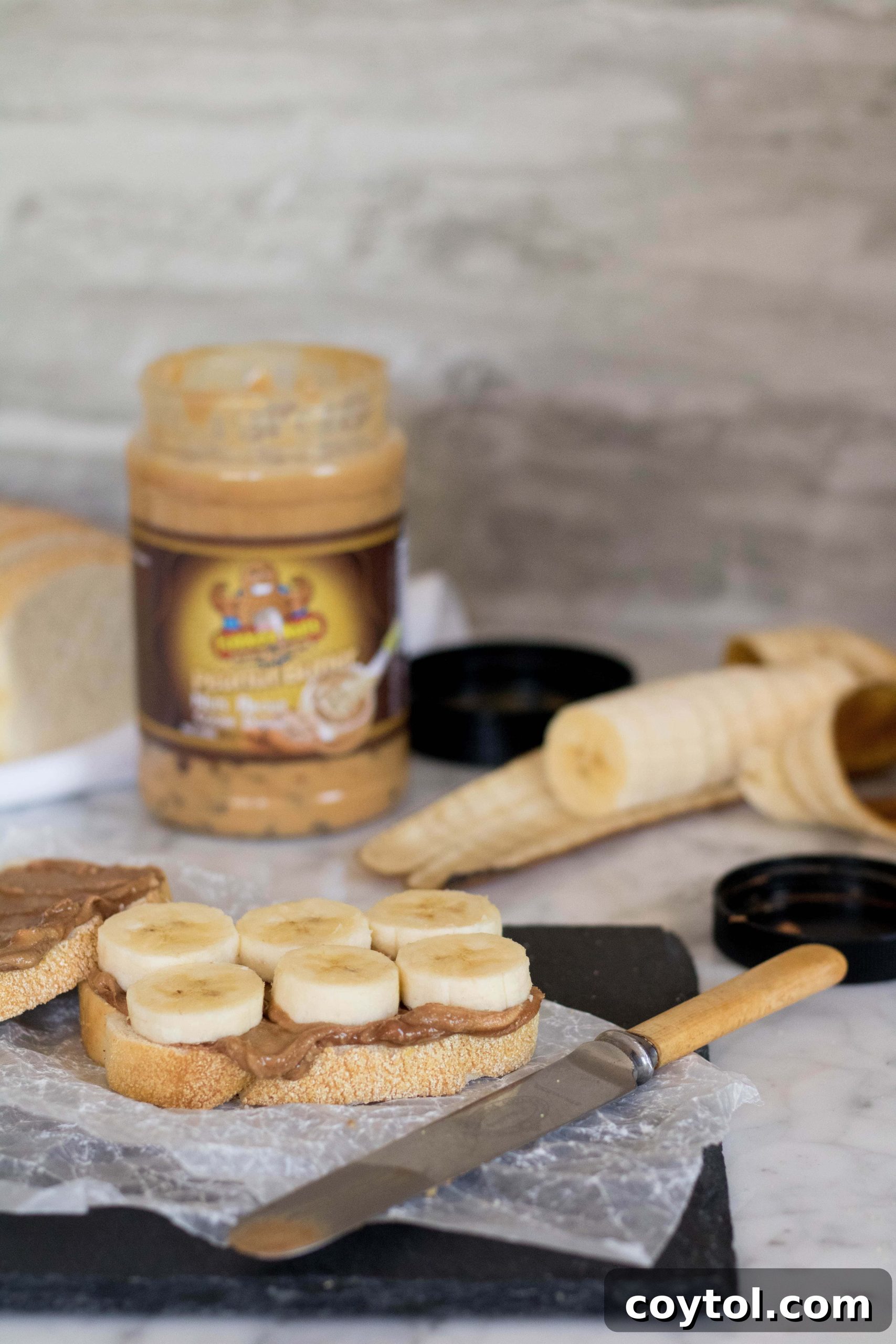Spreading peanut butter on bread slices for the grilled sandwich