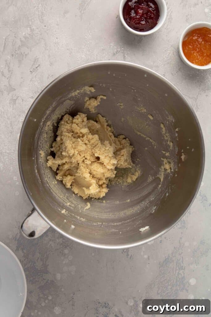 Step-by-step image: Mixing the cookie dough to achieve the right consistency for almond flour thumbprint cookies, ensuring it's just combined.