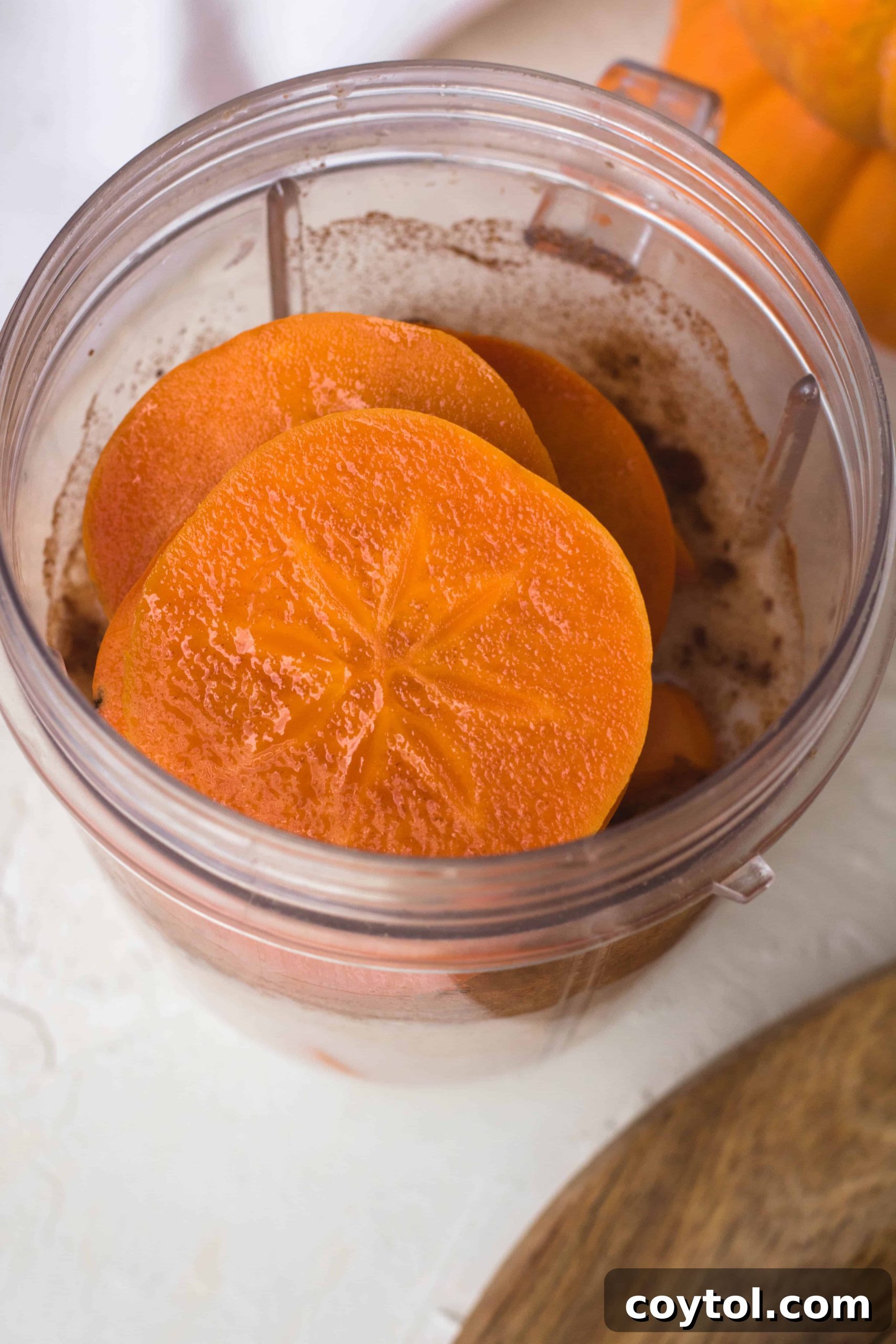 Fuyu persimmons sliced to show the unique star pattern of the core, highlighting the beautiful inner structure of the fruit.