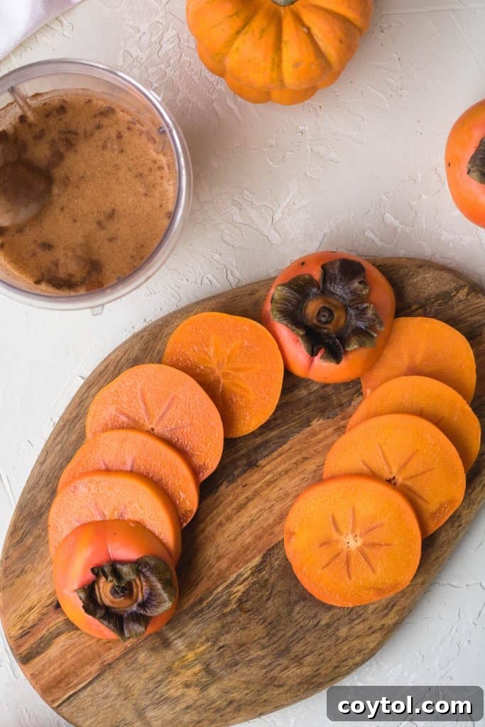 Fresh persimmons, washed and expertly sliced, laid out on a clean cutting board, ready for blending into a delicious smoothie.