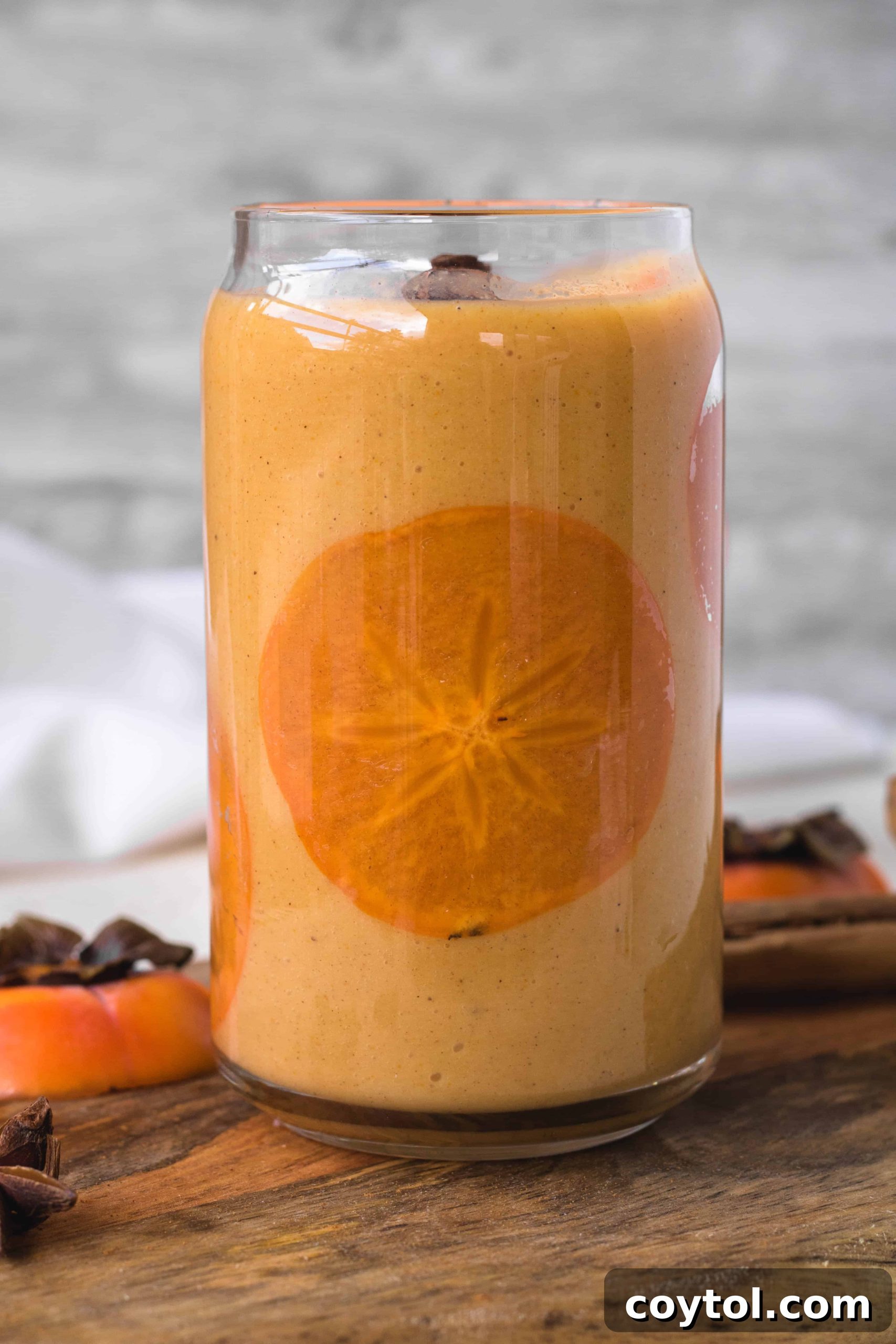Easy persimmon smoothie served in a glass, beautifully garnished with a thin persimmon slice, showcasing its vibrant color and smooth texture.