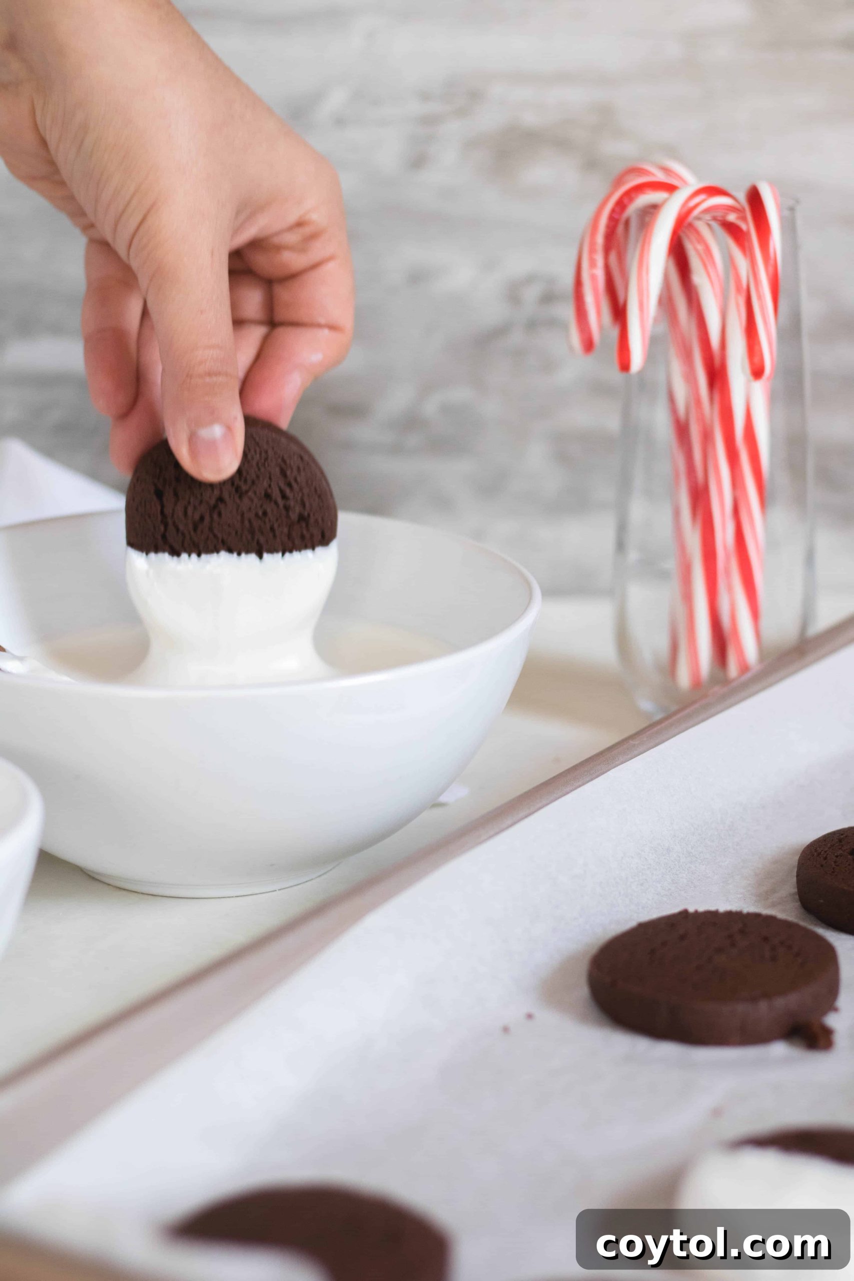 Dipping cookies in white candy melts and sprinkling with crushed candy canes