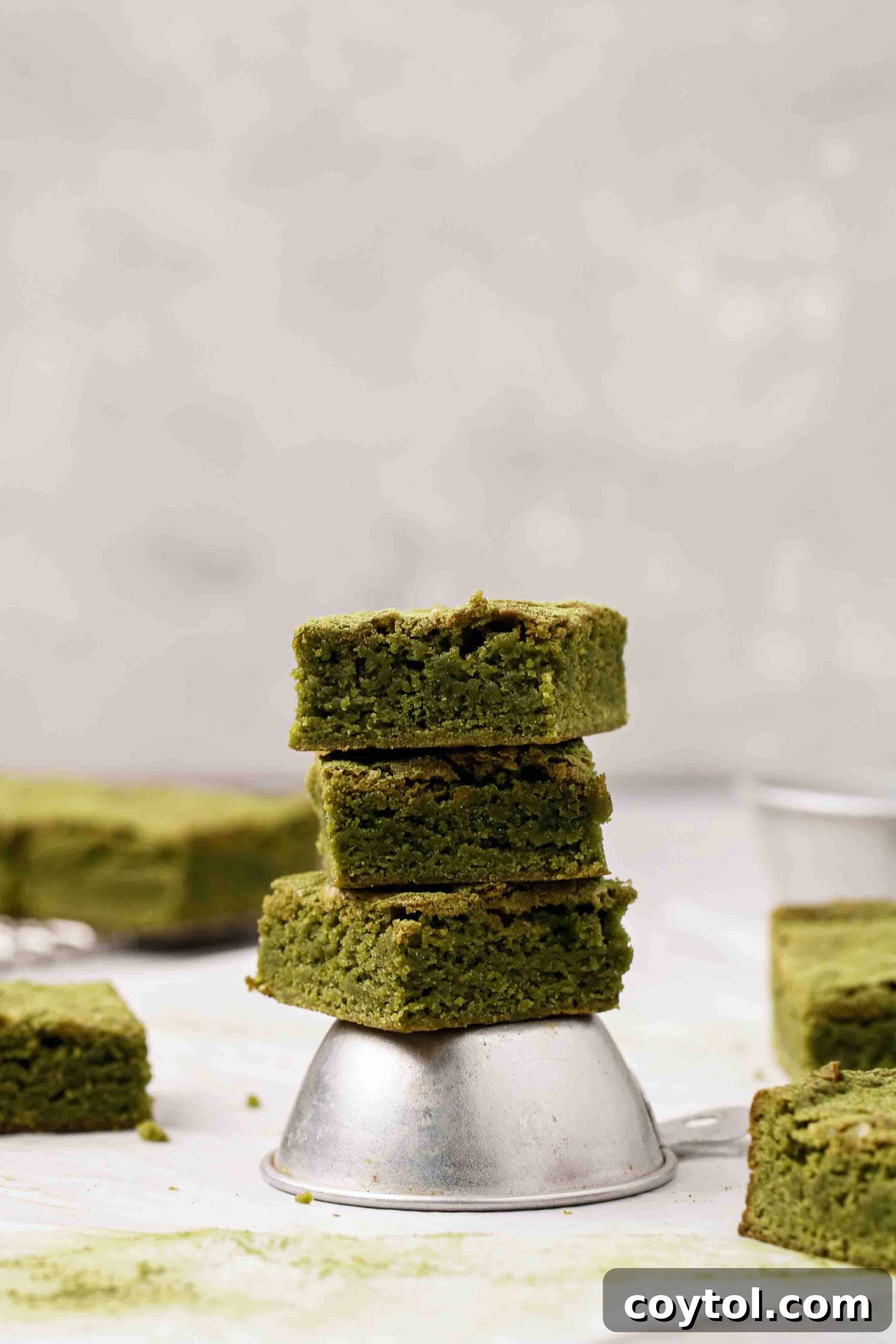 Matcha brownie slices stacked on a plate