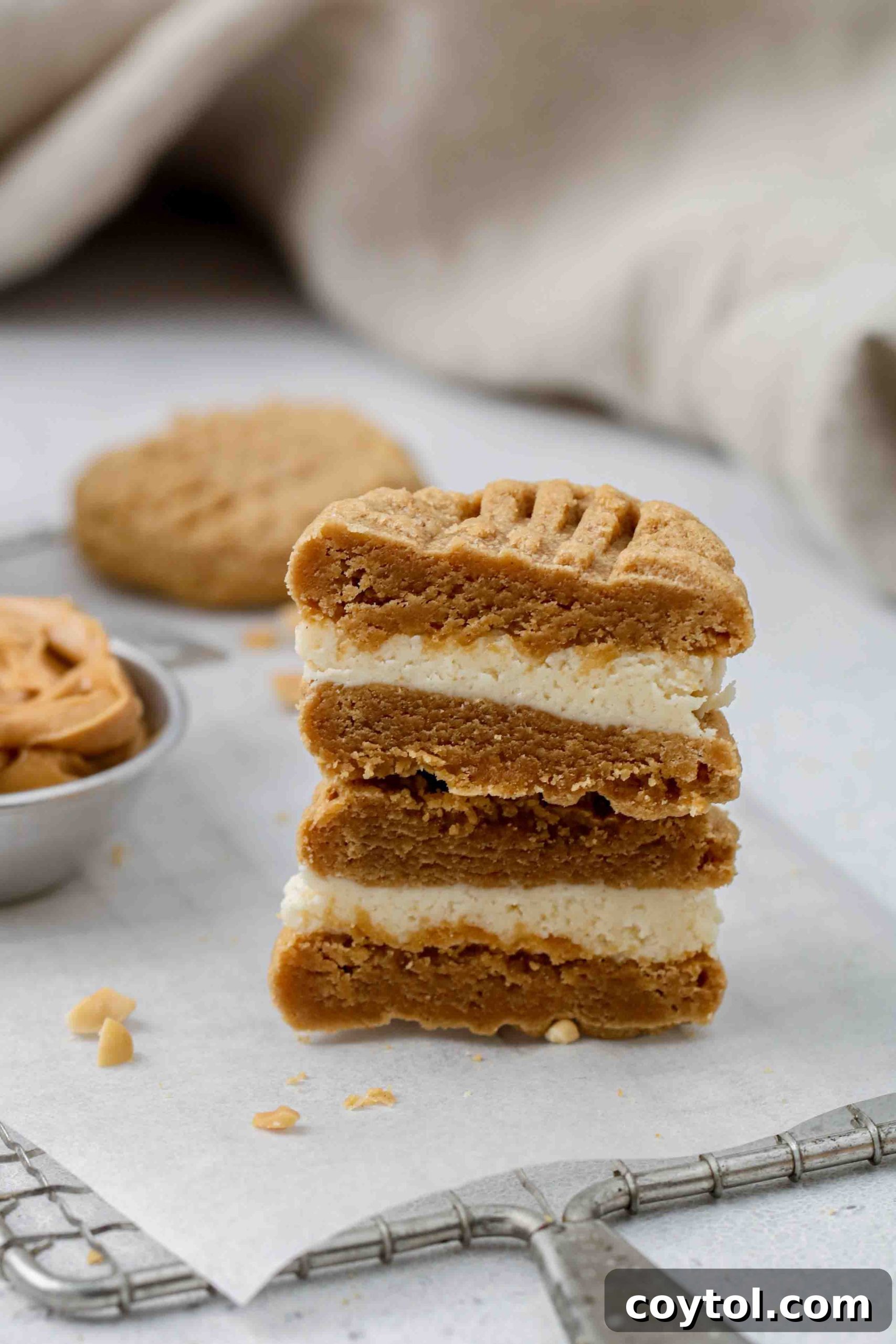 A stack of delicious stuffed peanut butter cookies on a cooling rack, showing their appealing texture and golden edges.