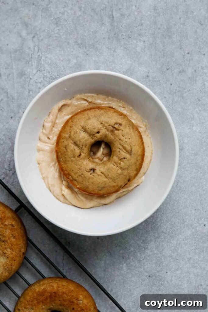 A banana donut freshly coated with brown butter glaze.