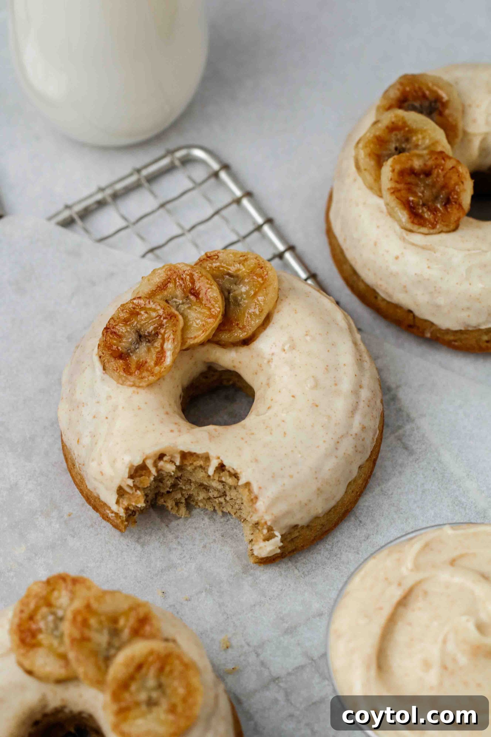 Artistic close-up photograph of a single banana donut, highlighting its texture.