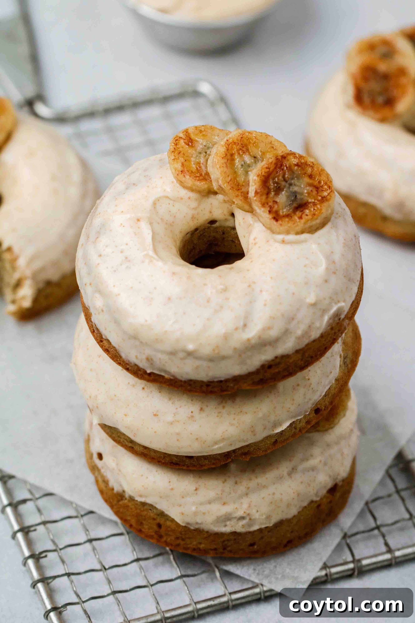 Stack of banana donuts with brown butter glaze, garnished with a sprinkle of cinnamon.
