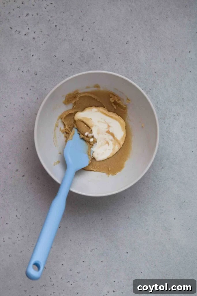 Adding cream to the creamed butter and sugar mixture
