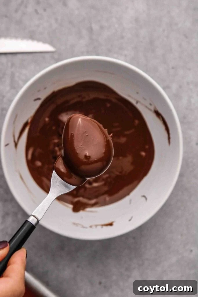 Dipping the peanut butter eggs in melted chocolate