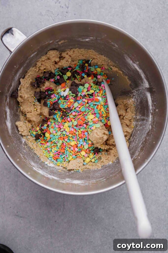 Folding chocolate chips and sprinkles into the cookie dough for festive Easter treats.