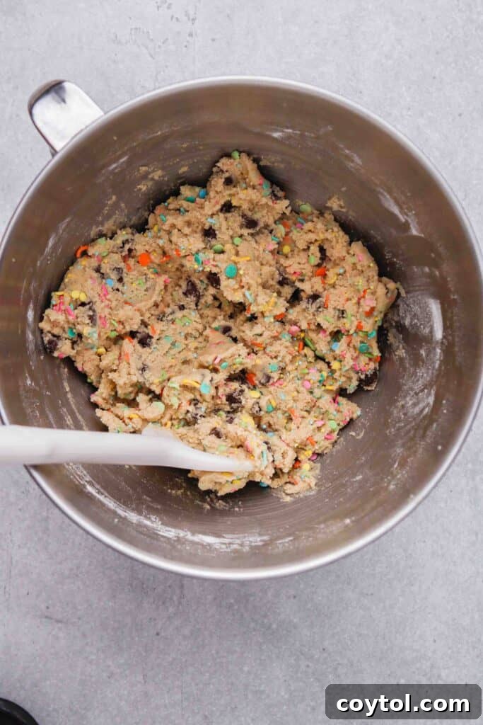 Portioned cookie dough balls studded with colorful sprinkles, ready for baking.
