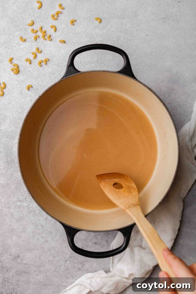 Unforgettable Stovetop Mac and Cheese 7 Adding water to the butter and flour mixture for the sauce base