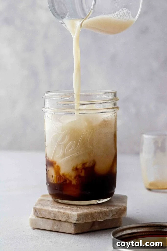 Brown Sugar Oat Espresso Velvet 10 Pouring oat milk into shaken espresso
