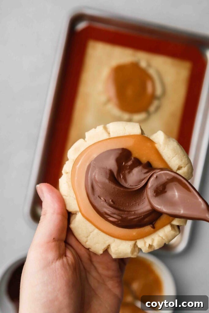 Spreading melted chocolate on sugar cookie