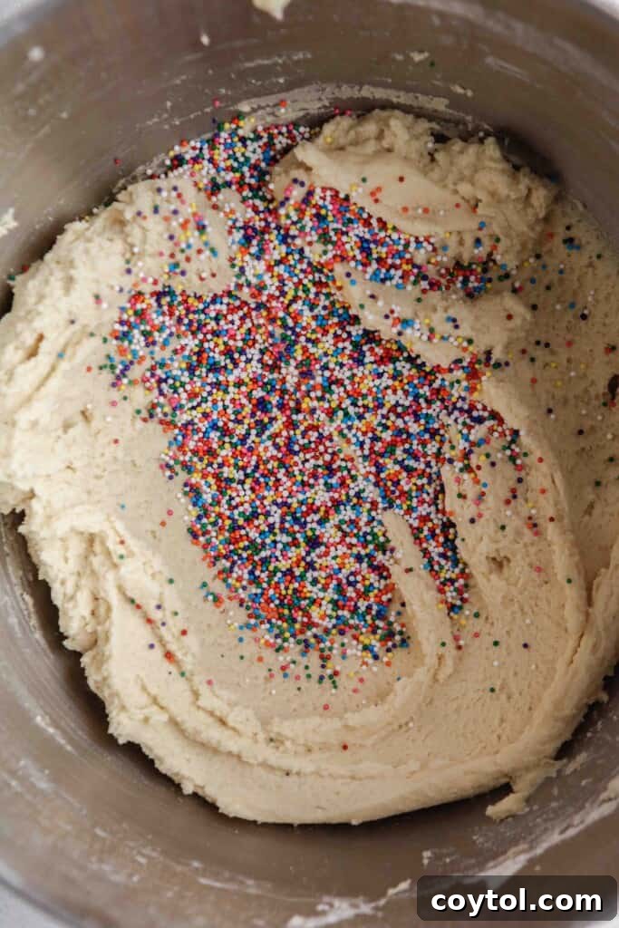Pillowy Soft Crumbl Circus Animal Cookies 8 Fold the colorful sprinkles into the cookie dough.