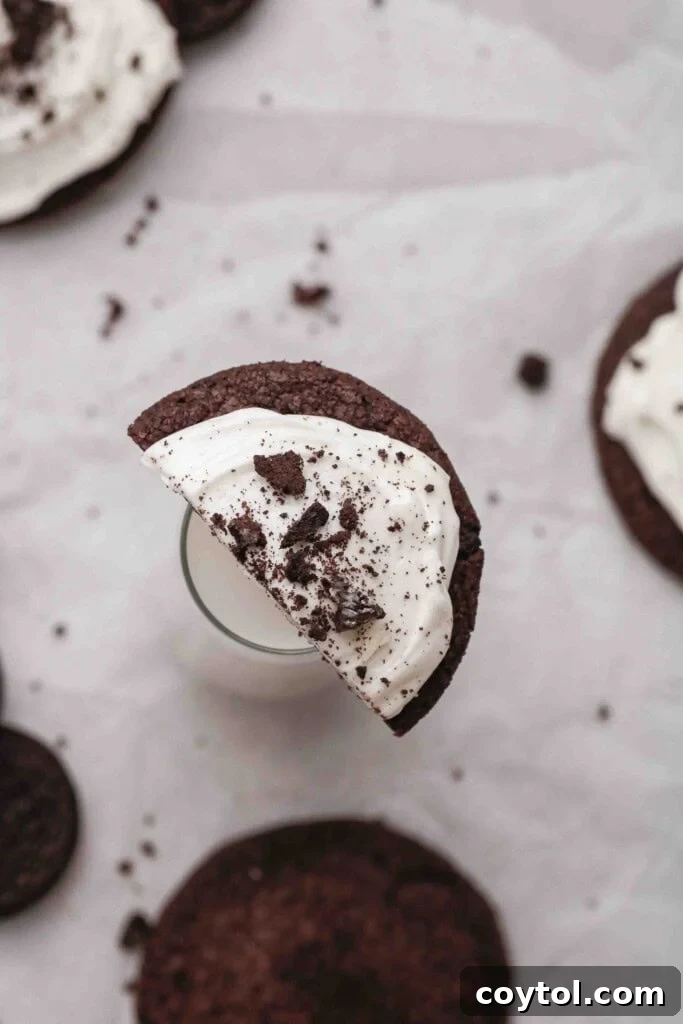 Homemade Crumbl Oreo Buttercream Cookies 14 Half frosted CRUMBL Oreo cookie next to a glass of milk