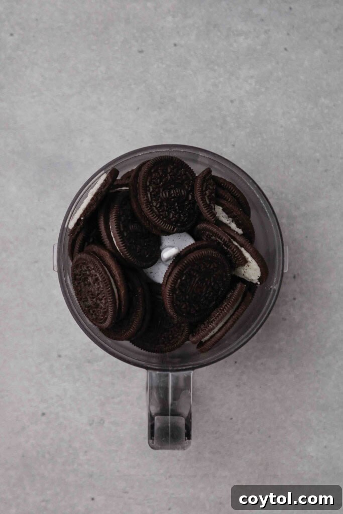 Homemade Crumbl Oreo Buttercream Cookies 5 Oreo cookies in a food processor being crushed for recipe