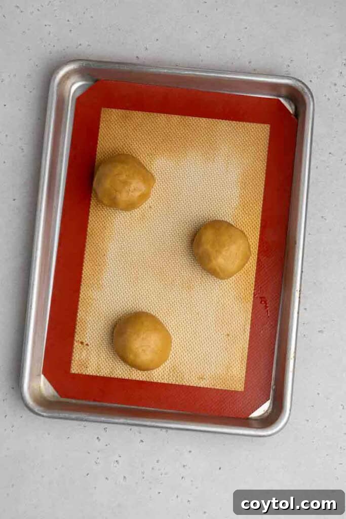 CRUMBL Waffle Cookies Crowned with Buttercream 6 Cookie dough balls on a baking sheet