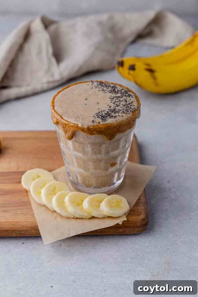 Golden Goodness Almond Banana Date Smoothie 7 A glass of healthy banana smoothie with a straw.