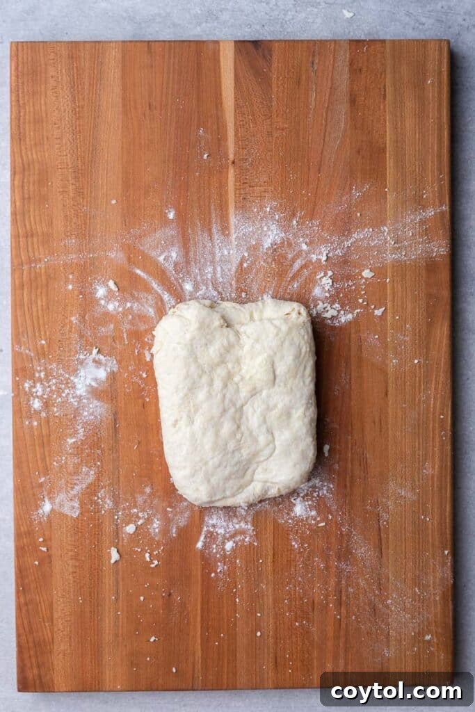 Folded biscuit dough on a floured surface