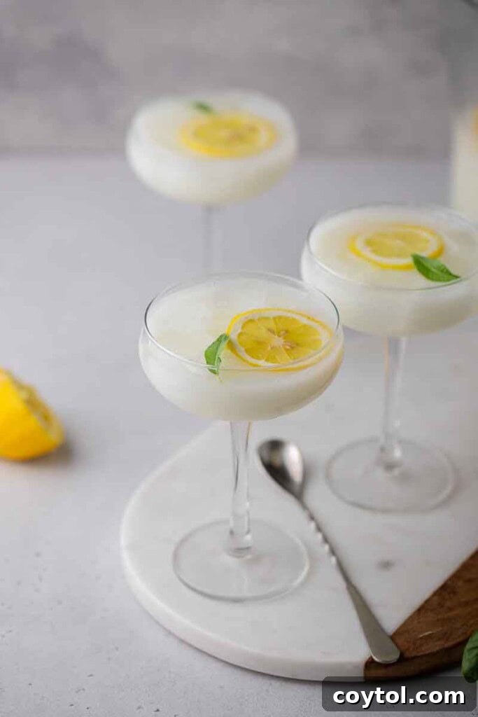 Refreshing summer drink made with sweetened condensed milk, served in a tall glass with lemon slices and ice