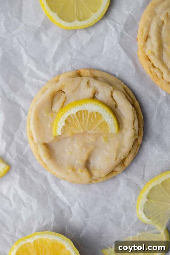 Effortless Bakery-Style Lemon Glaze Cookies 16 Overhead close-up of CRUMBL Lemon Glaze cookies with fresh lemon slices