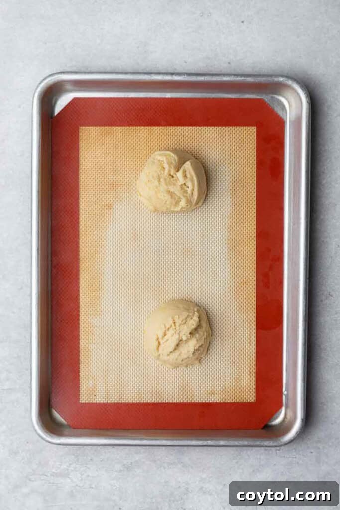 Effortless Bakery-Style Lemon Glaze Cookies 8 Portioned cookie dough balls on a baking sheet