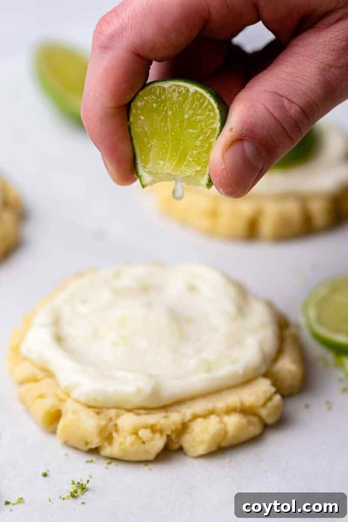 Zesty Island Chill Coconut Lime Cookies 13 Hand squeezing fresh lime juice over frosted CRUMBL cookies.