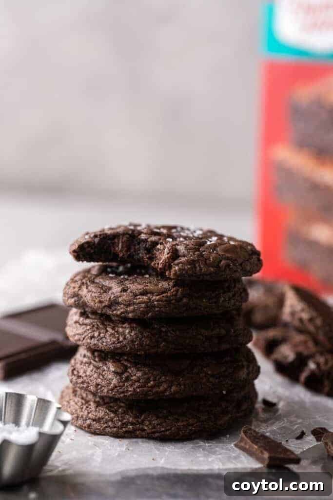 Decadent Crumbl Brownie Batter Cookies 16 A stack of three Crumbl brownie batter cookies, showing their thick, chewy profile.