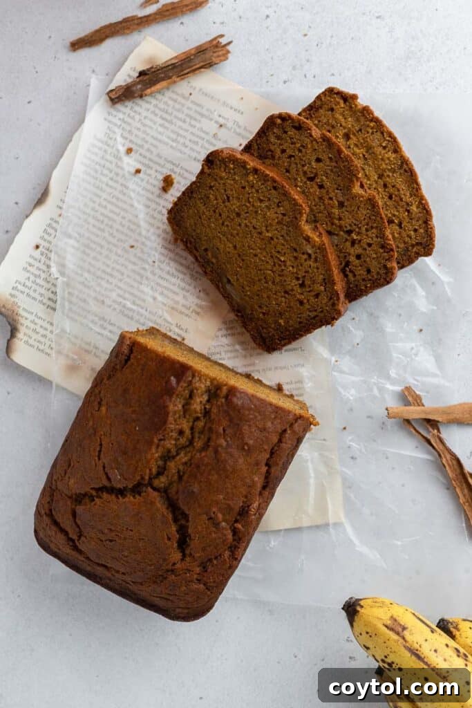 A freshly baked, golden-brown whole pumpkin banana bread loaf, cooling on a wire rack.