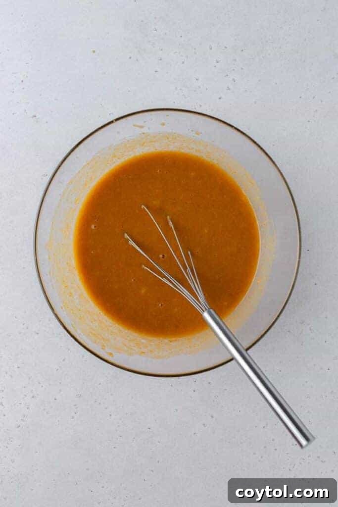 Close-up of the smooth, creamy wet ingredients mixture in a bowl, ready for dry ingredients.
