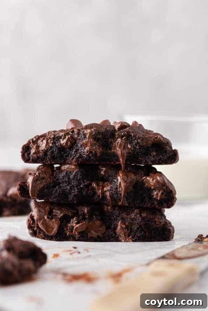 Thick Dark Dream Double Chocolate Cookies 2 A stack of three thick, soft Crumbl Dark Dream double chocolate cookies, showcasing their melted chocolate chips and gooey, fudgy centers. Perfect for chocolate lovers.