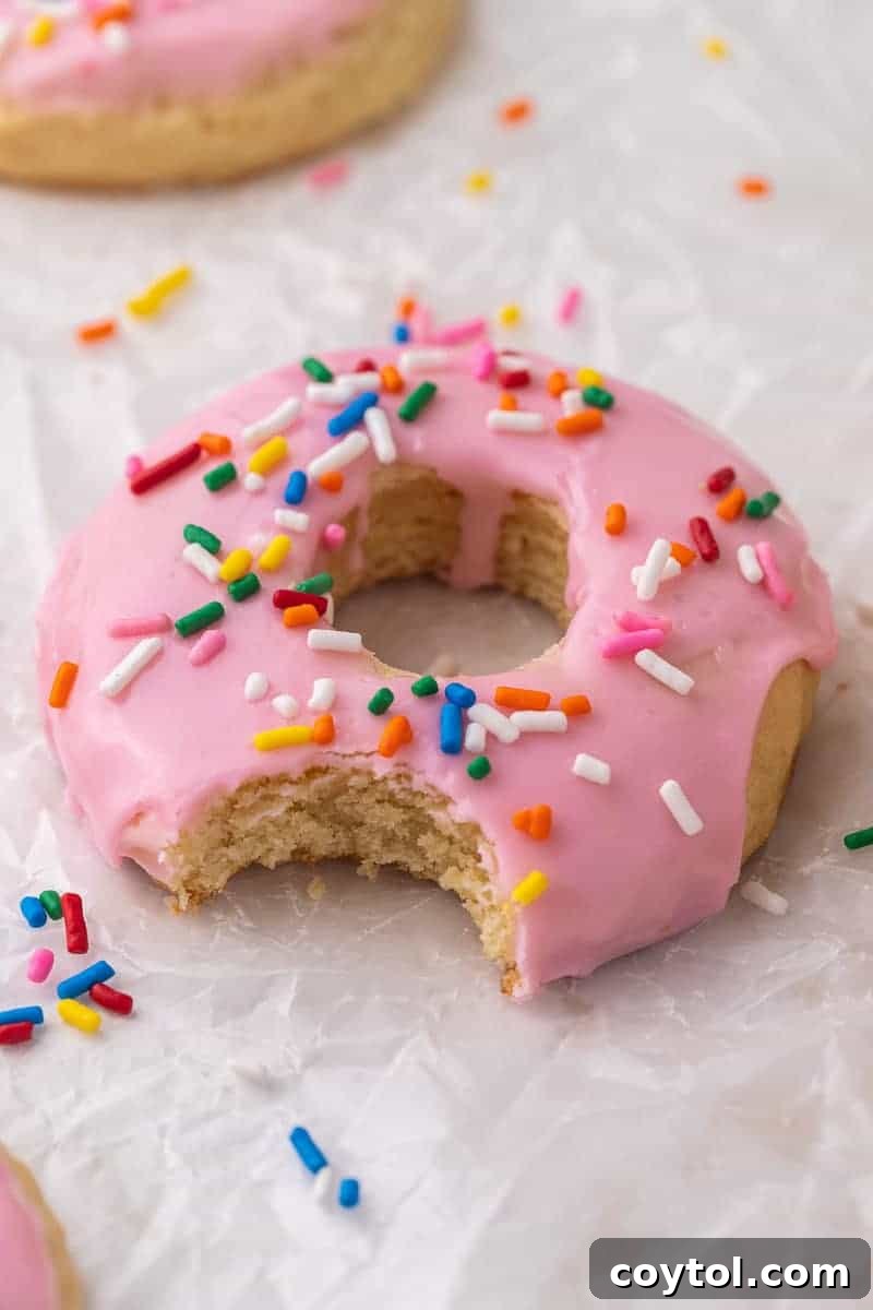 Charming Crumbl-style Pink Donut Cookies, soft sugar cookies with glossy pink glaze and festive sprinkles.