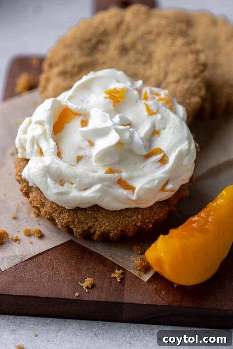 Luscious Crumbl-style peaches and cream cookies, with whipped mousse and peach frosting.