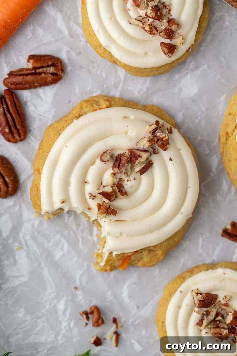 An overhead view of delicious Crumbl-style carrot cake cookies, topped with tangy cream cheese frosting.